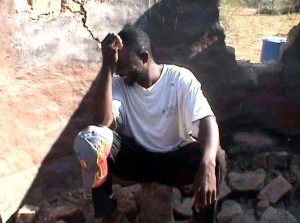 A man in Gokwe sits in the ruins of his house destroyed by youth militia  and war vets in May 2008. 