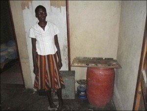 A pregnant woman stands in her empty kitchen, rural Gwanda, October 2011.